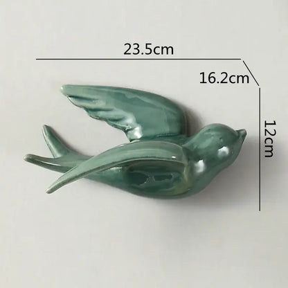 A sleek flying bird ceramic wall ornament in smooth sage green glazed ceramic for living room decor