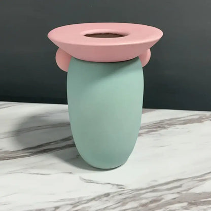 Pastel mint ceramic toothbrush holder with pink flower-shaped lid featured in decorbites geometric ball ceramic vase decor