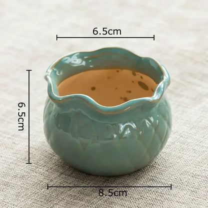 A small round lotus flower ceramic tea cup with teal glaze and scalloped rim for decorbites lotus flower decor