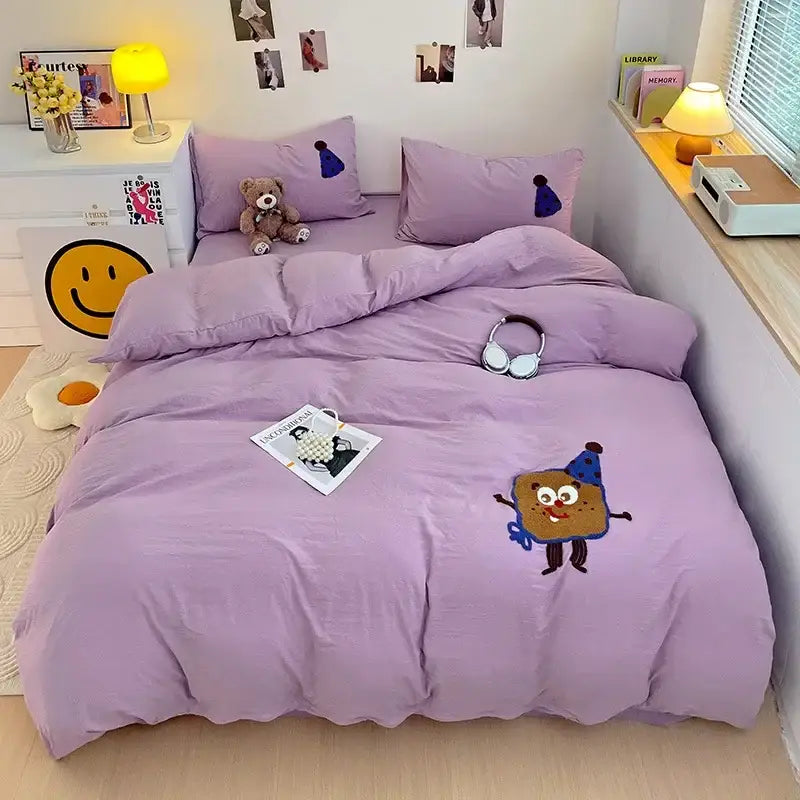 Lavender bedding set with decorbites cartoon towel embroidery featuring playful cookie character and blue party hat