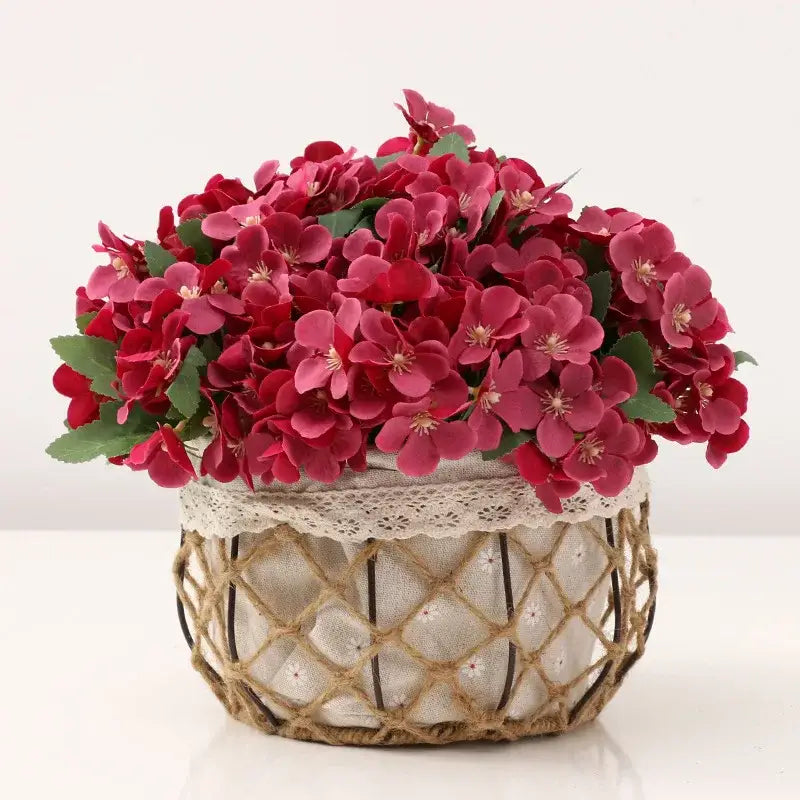 A vibrant red artificial hydrangea begonia flower dry bouquet in a woven basket with lace trim for living room decor