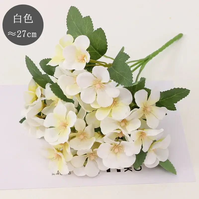 A delicate white begonia flower dry bouquet with soft yellow centers and green stems for dry flower embossing decor
