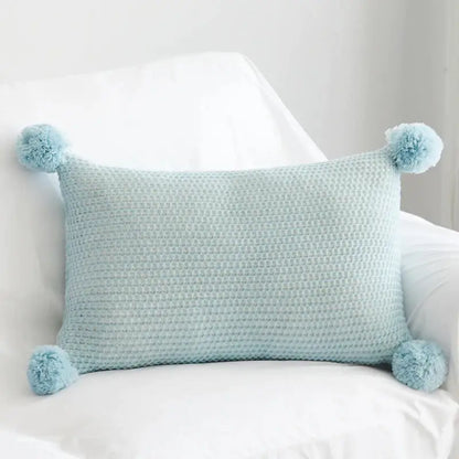Light blue waffle-knit cushion cover with fluffy knit pompom balls at each corner for bedroom decorbites decor