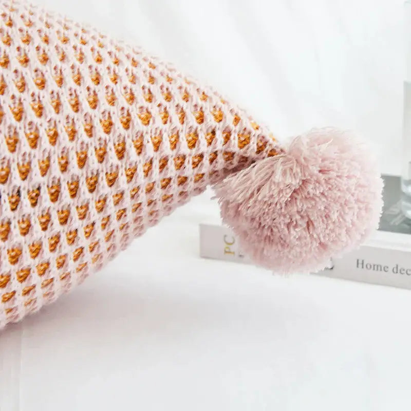 Pastel knit pompom ball cushion cover in soft pink and gold knitted fabric with a fluffy pom-pom decorbites knit pompom