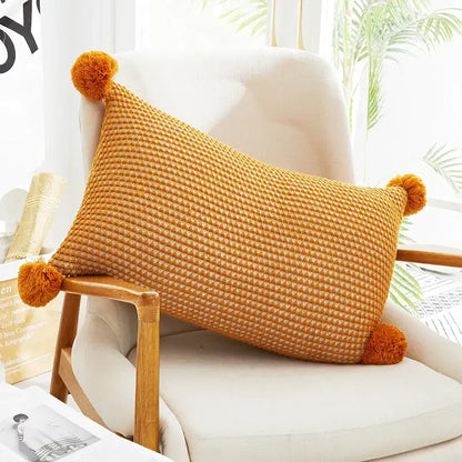 Warm orange woven cushion cover with fluffy knit pompom balls at corners decorbites knit pompom decor