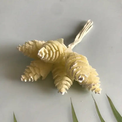 A cluster of pale yellow intricately textured artificial pinecones in a pastel artificial flower wreath for living room decor