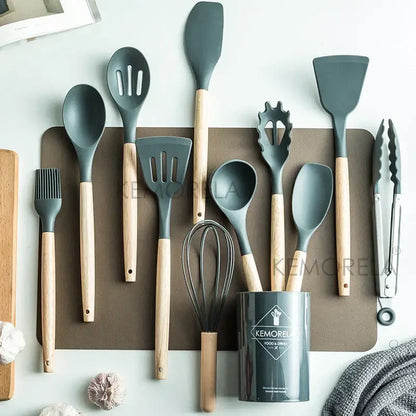 Set of gray silicone kitchen utensils with wooden handles and matching cylindrical storage canister in ceramic cup