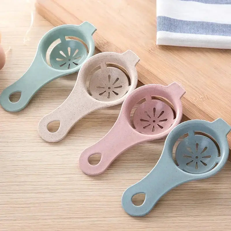 Pastel-colored egg white separator with handle and star-shaped perforations for easy egg white separation