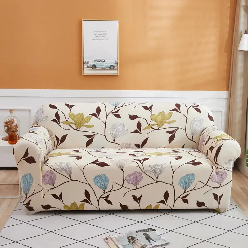 Cream-colored stretch sofa cover with floral pattern in brown, light green, purple, and blue for living room use