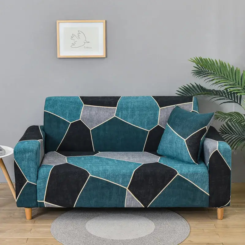Patchwork mandala printed stretch sofa cover with teal and black geometric pattern and white stitching accents for living room