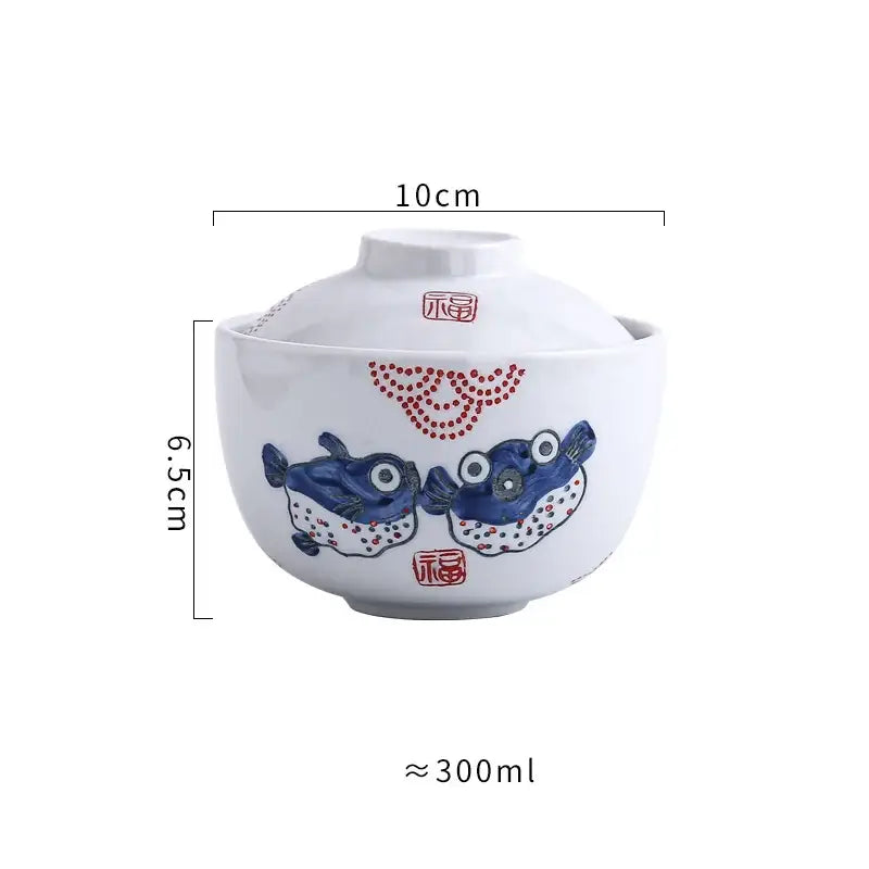 White ceramic stew pot bowl with matching lid featuring hand-painted blue pufferfish and red decorative dots