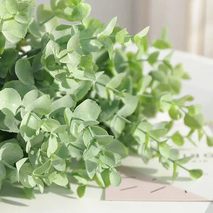 A delicate peach and green eucalyptus leaves artificial arrangement with soft light green decorbites eucalyptus leaves stems in a living room vase
