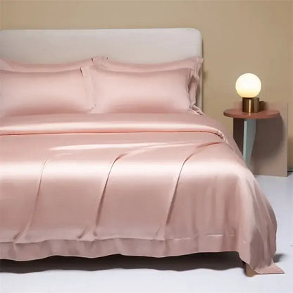 A soft blush pink satin cooling cotton solid bedding set with a glossy finish and elegant ruffled edges
