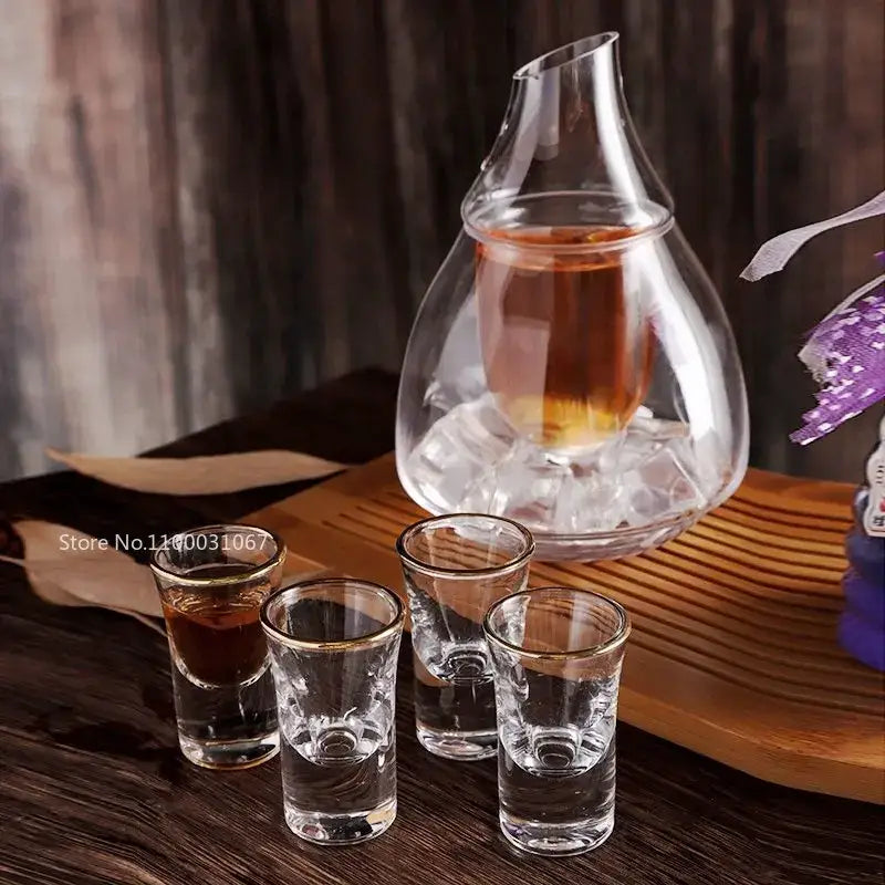 Clear glass wine decanter and ice jug set with gold rimmed shot glasses featuring etched patterns for dining room decor