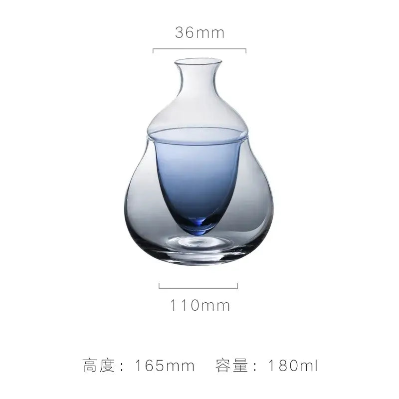 Pear shaped glass wine decanter with gradient blue interior and narrow neck in an ice jug set for dining room decor