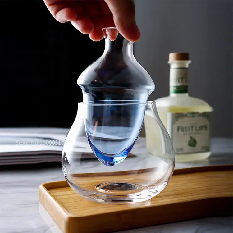 Pear shaped clear glass wine decanter with blue tinted base in an elegant ice jug set for dining room decor