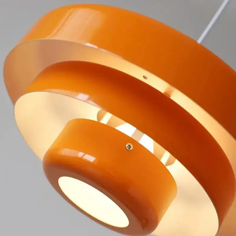 Vibrant orange glossy acrylic pendant lamp with concentric circular rings in bauhaus style pendant lighting design