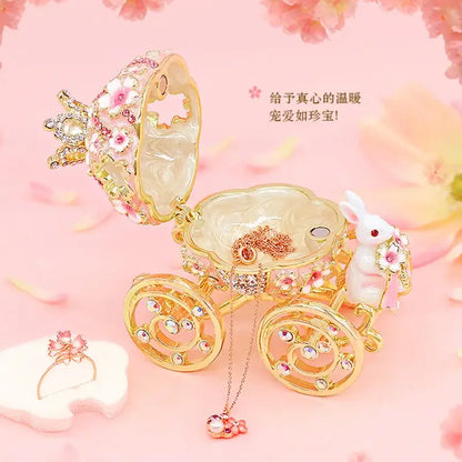 Pink and gold princess carriage jewelry trinket box adorned with rhinestones floral patterns and white rabbit figurine