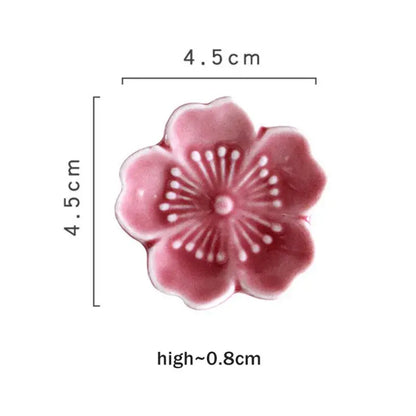 Pink and green decorbites ceramic sakura chopstick rest shaped like a delicate pink ceramic cherry blossom dish with white stamens