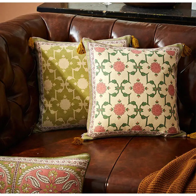 Two square decorative throw pillows with pink and green datura flowers print and tassels for living room decor