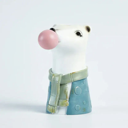 White ceramic polar bear figurine wearing green scarf and blue polka-dot pants blowing pink bubble gum flower vase decorbites bubble gum
