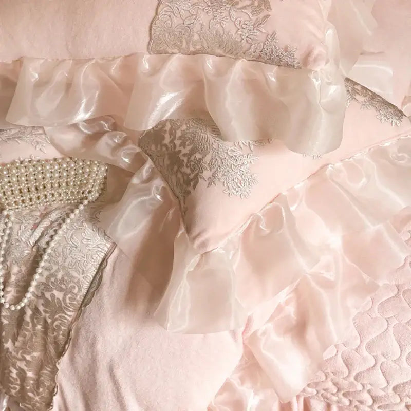A blush pink satin pillow sham with silver decorbites french lace ruffles from a bedding set for bedroom decor