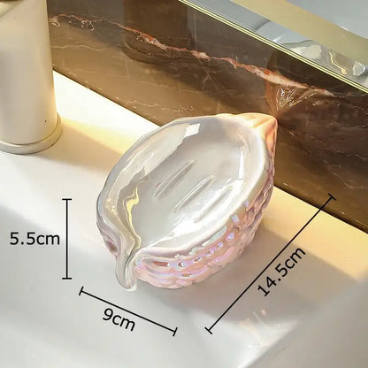 Glossy iridescent pink seashell soap dish with textured base and grooves in pink and yellow bitter gourd ceramic soap rack