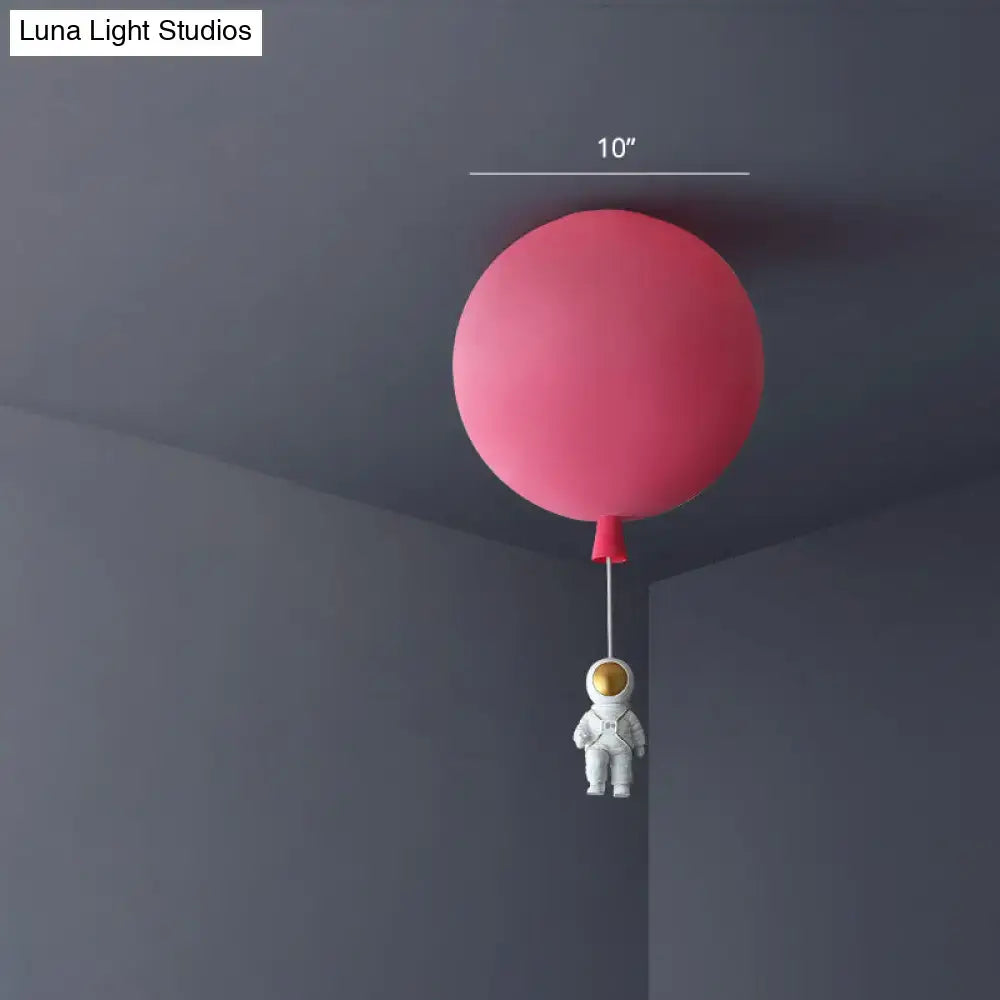 Pink astronaut ceiling lamp featuring a pink balloon-shaped acrylic pendant light with a white astronaut figurine for kids bedroom
