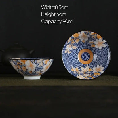 A decorbites blue and white porcelain hand-painted ceramic bowl with floral pattern and orange center on matching saucer