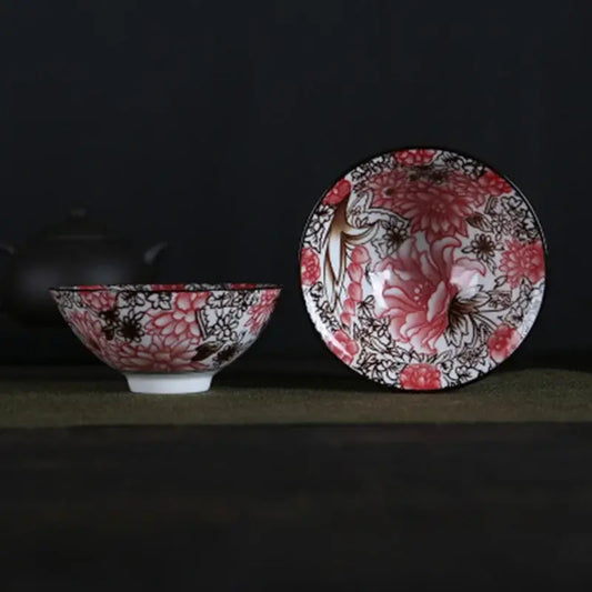 A pair of white porcelain hand-painted bowls with intricate pink and black floral patterns and glossy finish