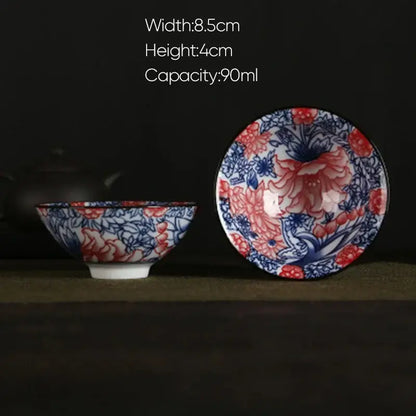A delicate white porcelain hand-painted tea bowl with blue and red floral pattern and glossy glaze finish by decorbites blue