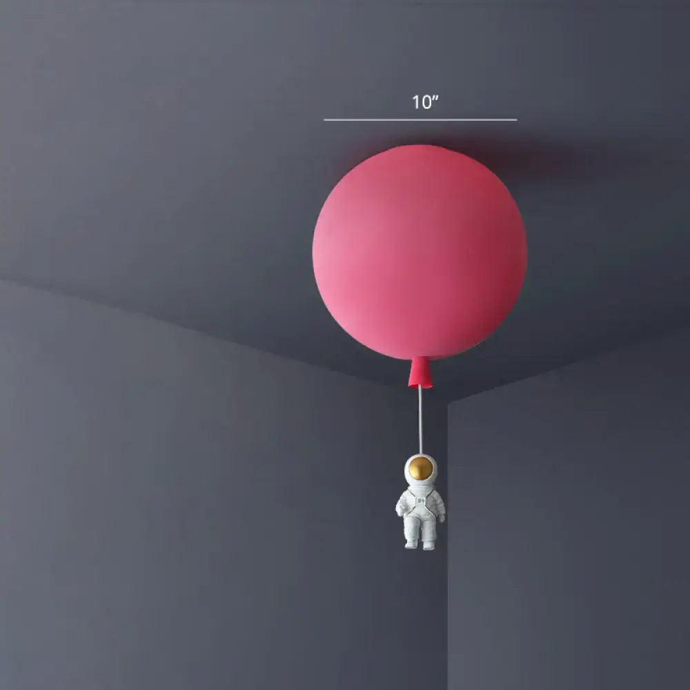 Pink balloon-shaped ceiling lamp with a small astronaut figurine hanging below astronaut ceiling lamp for bedroom
