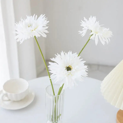 Three white artificial daisies in a clear glass pink brushed gerbera vase with vertical ridges for living room decor