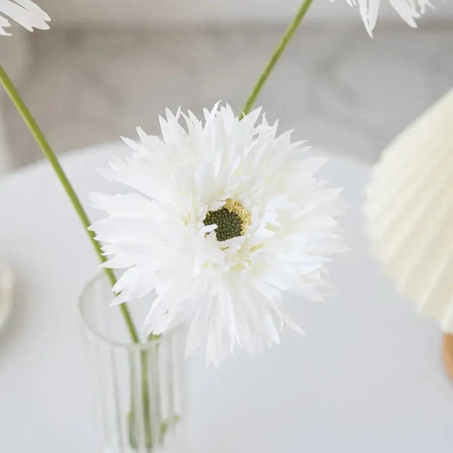 White artificial daisy with spiky petals and textured center in pink brushed gerbera vase for living room floral decor