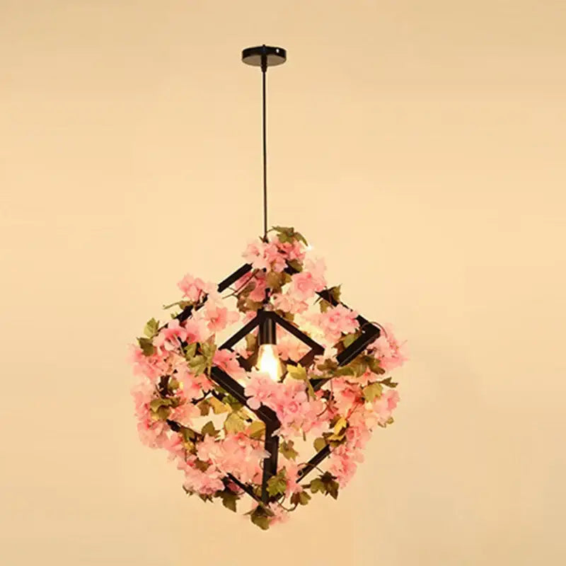 Delicate pink floral pendant light with black geometric frame featuring plants cherry blossoms for dining room decorbites green plants