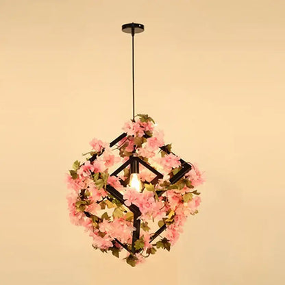 Delicate pink floral pendant light with black geometric frame featuring plants cherry blossoms for dining room decorbites green plants
