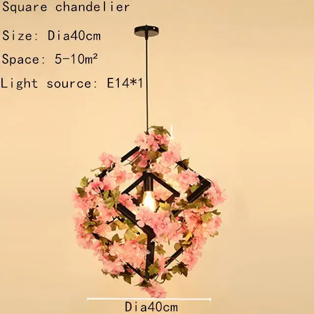 A square chandelier pendant light with black metal frame, pink cherry blossoms, green plants decorbites, and e14 bulb
