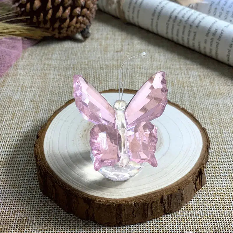 Pink and clear crystal butterfly figurine with faceted wings on a rustic wooden base for bedroom decorbites decor