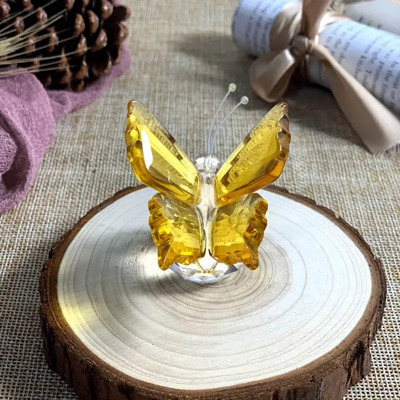 Translucent yellow crystal butterfly figurine with faceted wings and clear antennae on wooden base for bedroom decor