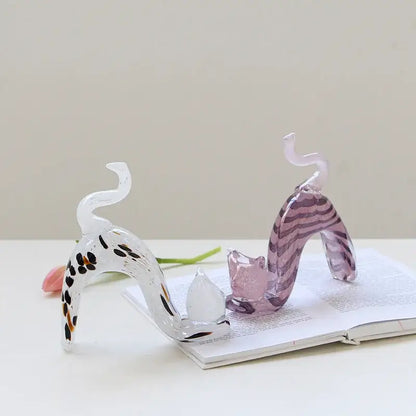 Two translucent glass cat figurines with black orange spots and purple stripes in a pink crystal cat living room decorbites statue