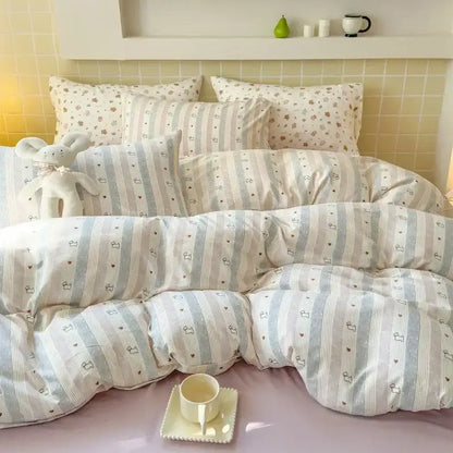 Soft pastel striped duvet set with heart and bunny motifs in light blue paired with pink floral jacquard fitted sheet set