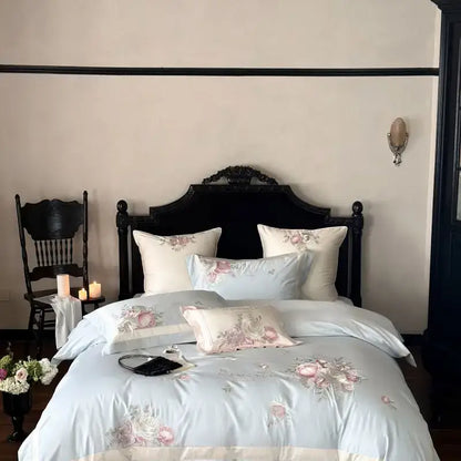 Light blue satin bedding set with delicate pink flowers embroidery and matching pillows for elegant bedroom decor