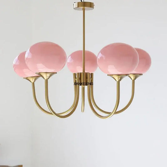 Delicate pink glass globe designer loft pendant light with polished brass finish and curved arms for bedroom decorbites