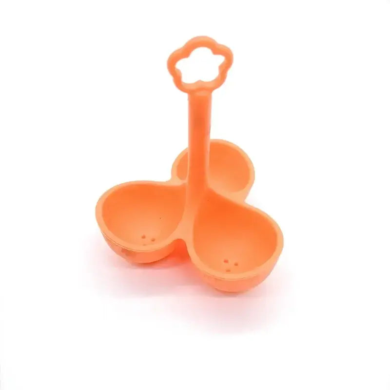 Orange plastic three-compartment serving dish with flower-shaped handle alongside pink and lavender silicone egg steamer tray