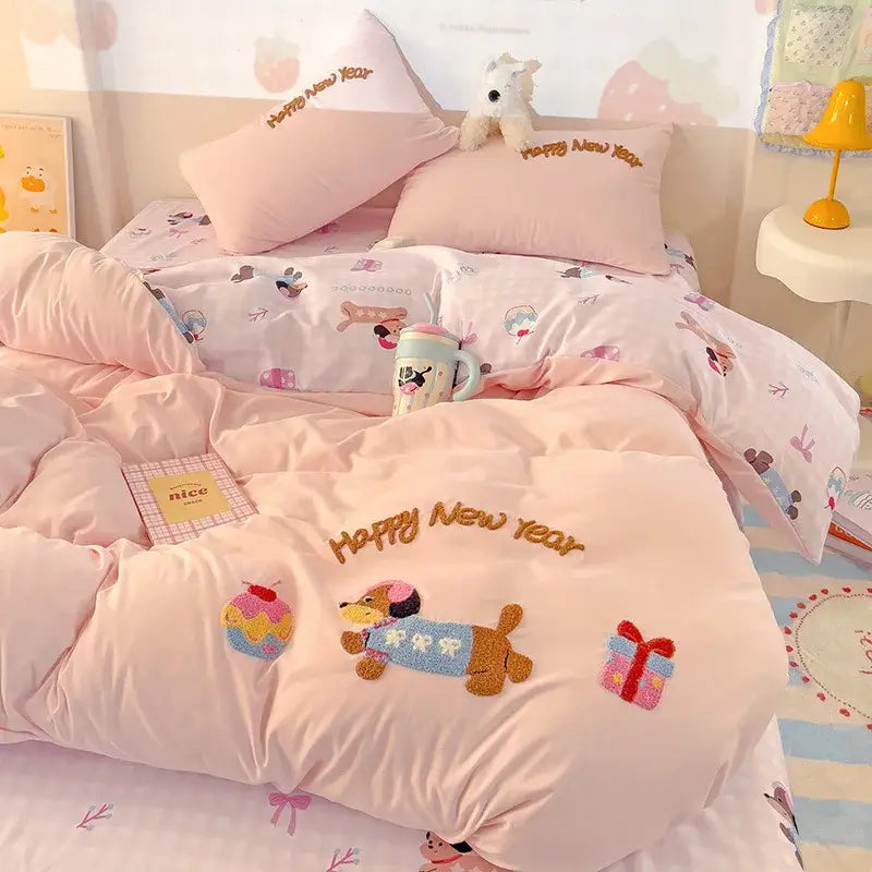Pastel pink quilted bedding set with embroidered happy new year text and playful dog appliqués in decorbites cloud cotton