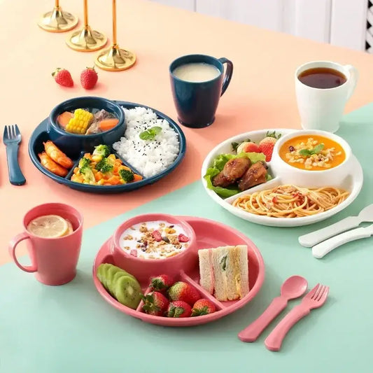 Pink plastic portion control plate with segmented compartments holding kiwi, strawberries, and a sandwich for kids meals