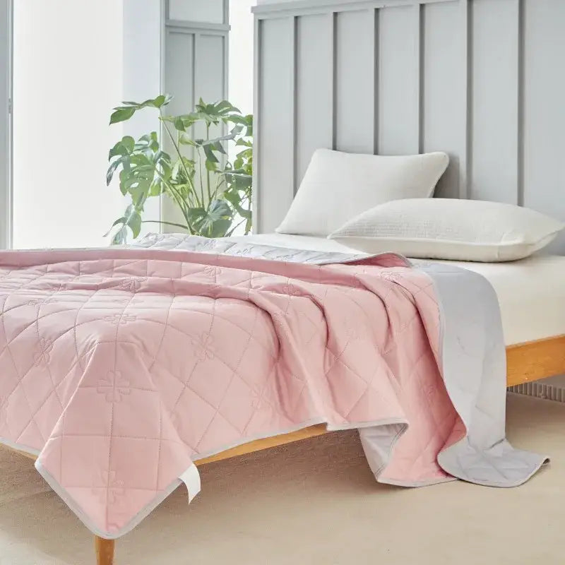 Pink quilted cool summer blanket with subtle cross-stitch pattern and soft plush texture for bedroom cooling comfort