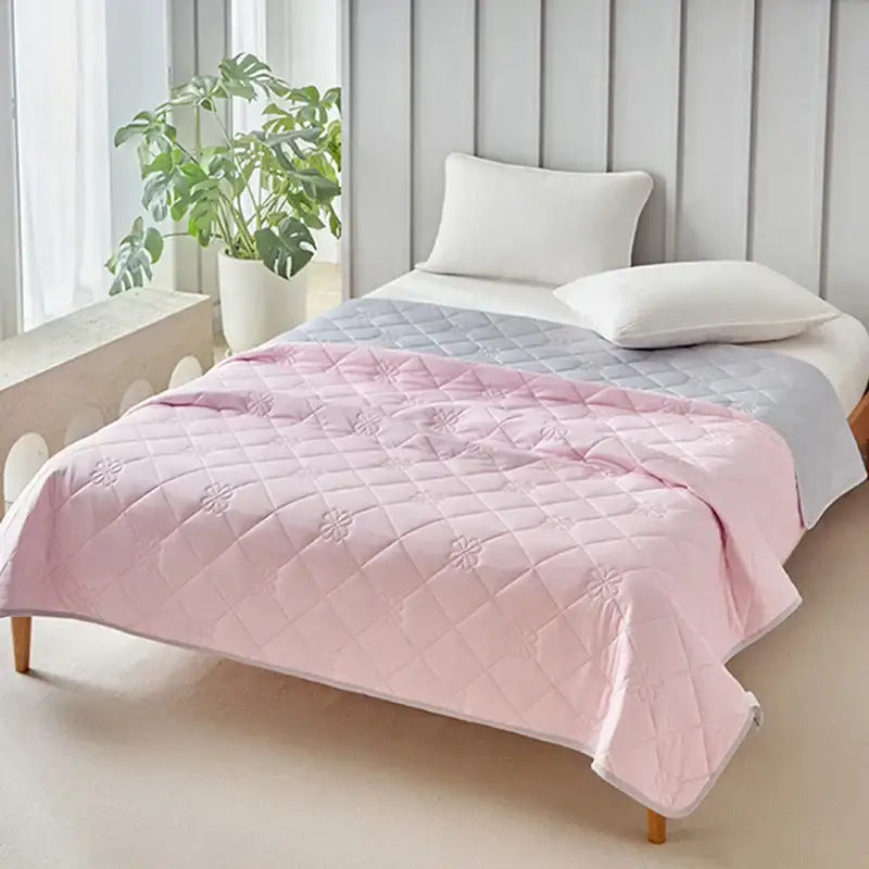 Pink quilted cool summer blanket with subtle floral embroidery pattern designed as a breathable summer blanket