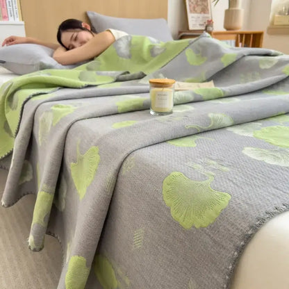 Soft gray decorbites cotton towel blanket with lime green ginkgo leaf pattern, textured weave, and frayed edges