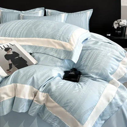 Light blue satin duvet cover set with cream piping and subtle woven leaf pattern for elegant bedroom use